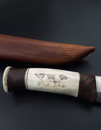 Handverziertes Jagdmesser 300 Lagen H.R 60 Klingenlänge 16 cm mit Griff aus Geweih, Schaftholz Nuss und Scrimshaw Veredlung